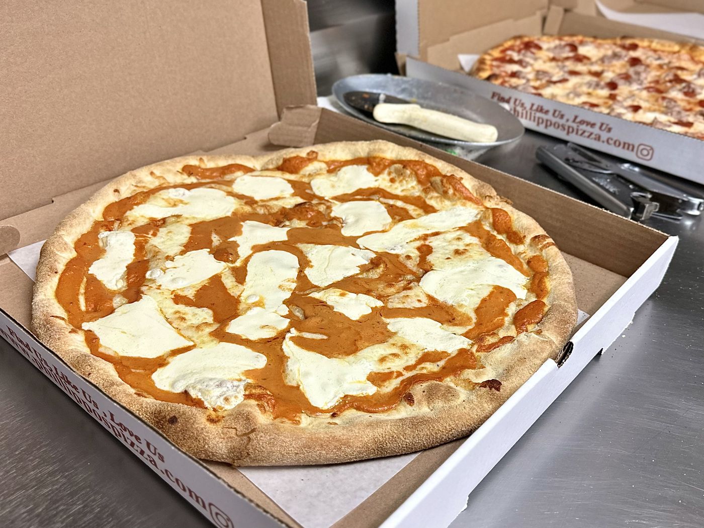 Margherita pizza with fresh mozzarella in a takeout box