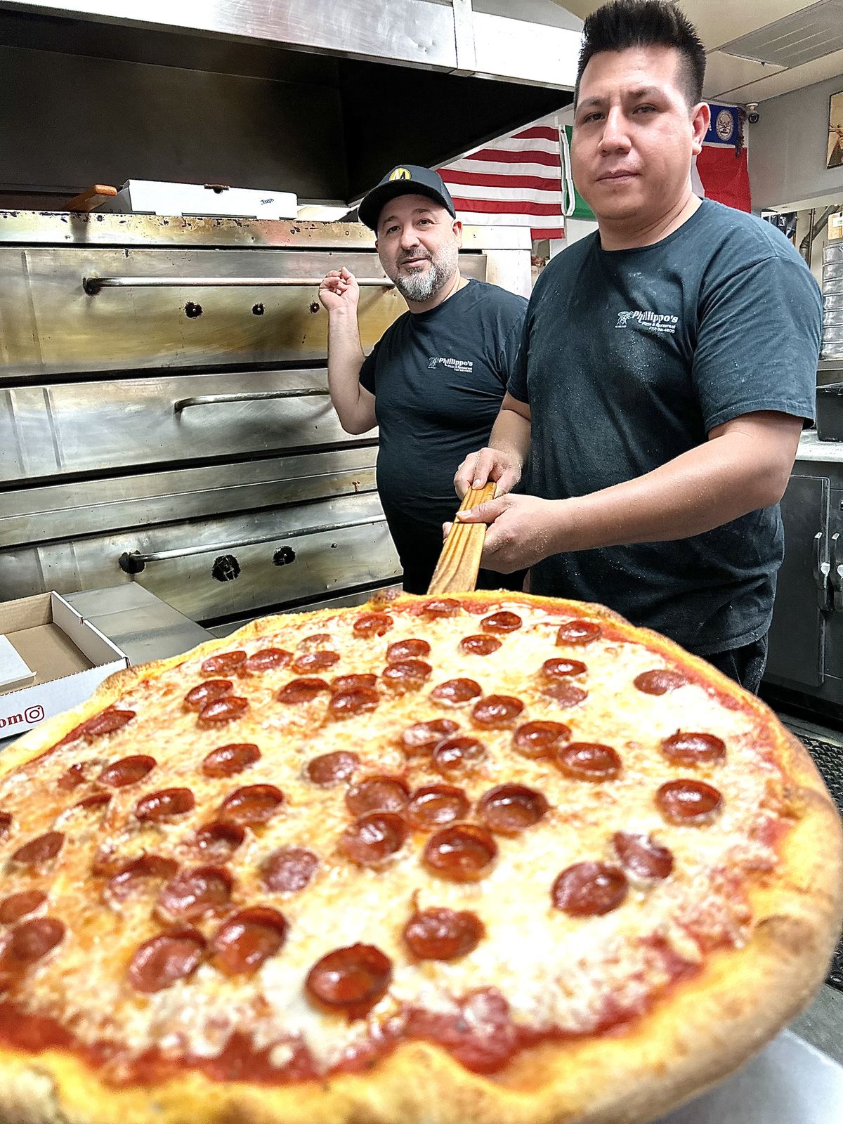 A whole pepperoni pie on the wooden peel, fresh from the oven
