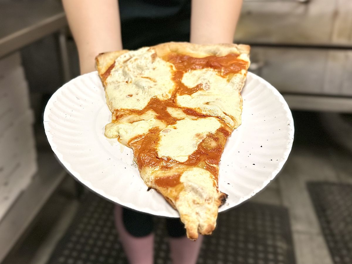 A classic New York style cheese slice on a paper plate
